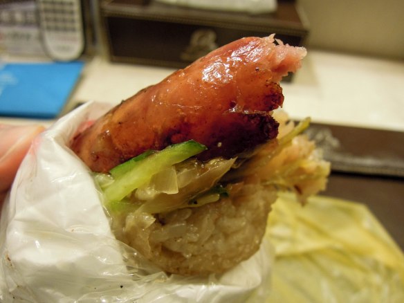 大腸包小腸 dàcháng bāo xiǎocháng ;Small sausage wrapped in a large sausage; the big sausage, which acts as a bun is actually sticky rice in a sausage casing.