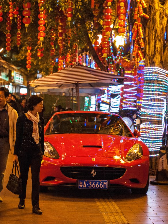 Ferrari parked  on the sidewalk in front of a high end seafood restaurant in Guangzhou.